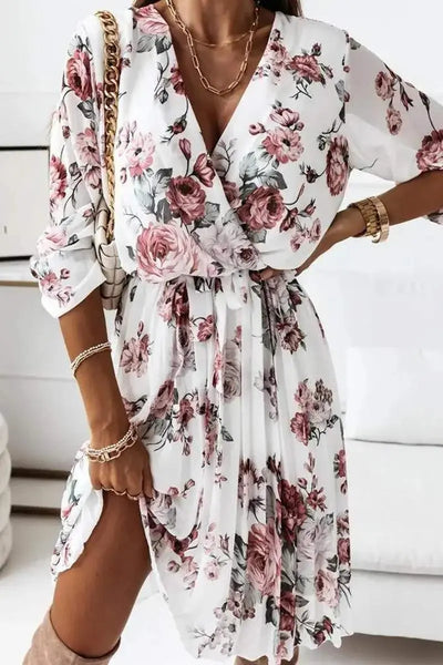 Woman wearing white floral v neck long sleeve dress.